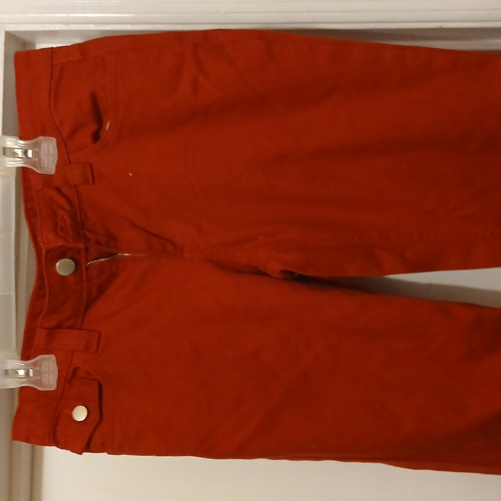women's burgundy pants with 2 pockets and silver snaps on the front and back